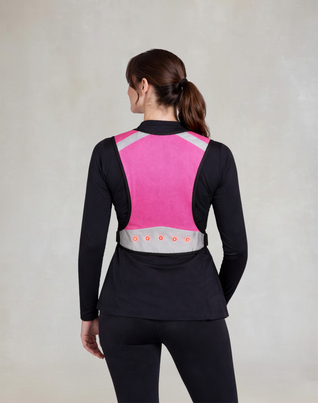 Pink hi-vis riding vest rear view with red LED lights, designed for low light visibility and safety