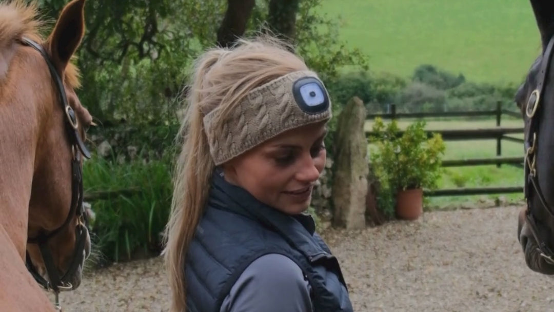 Lady wearing EquiLight merino wool LED headband with rechargeable hands-free LED light, designed to provide warmth, comfort and improved visibility for outdoor use in low-light conditions

